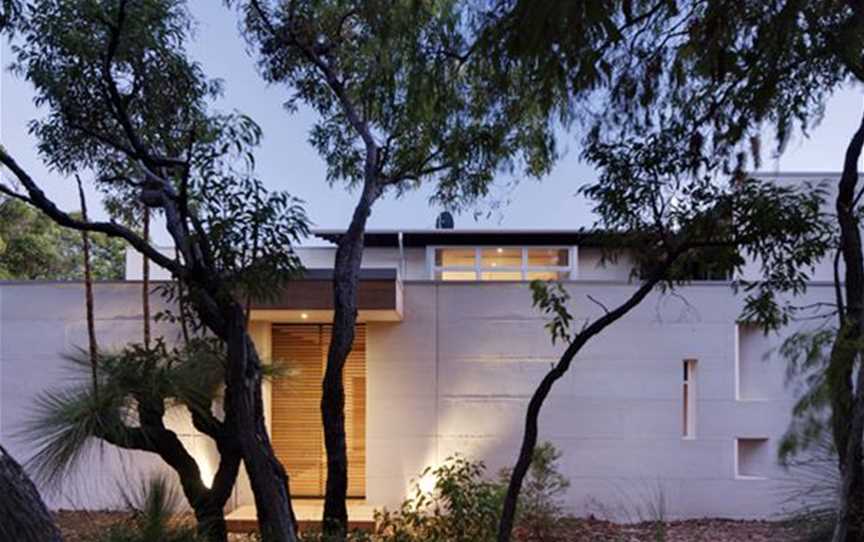 Front elevation of the parallel limestone walls, with the teak slated sliding screen to the covered entry