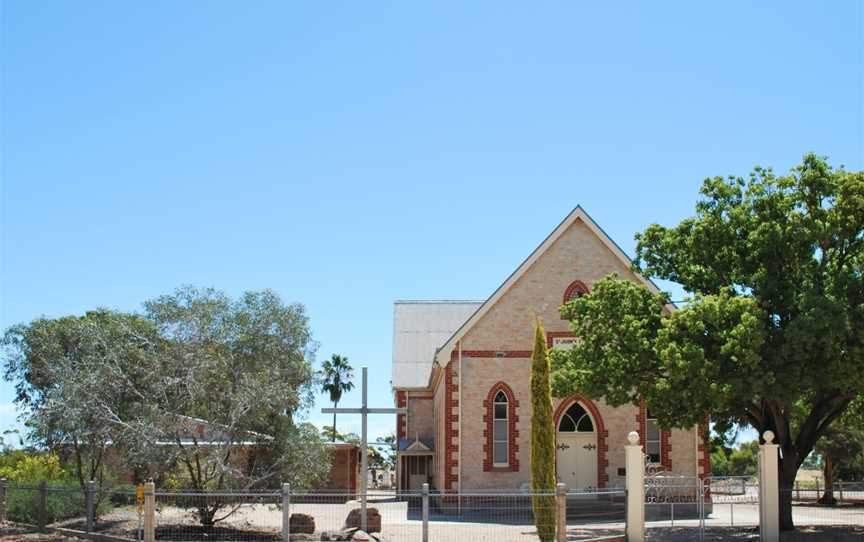 Stone church building with a cross in front