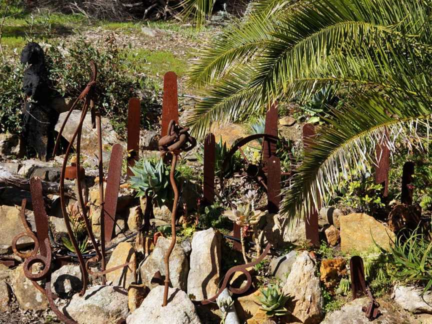 Boot hill, a chainsaw bar graveyard surrounded by suculents and sculptures.