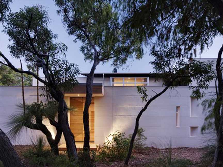 Front elevation of the parallel limestone walls, with the teak slated sliding screen to the covered entry