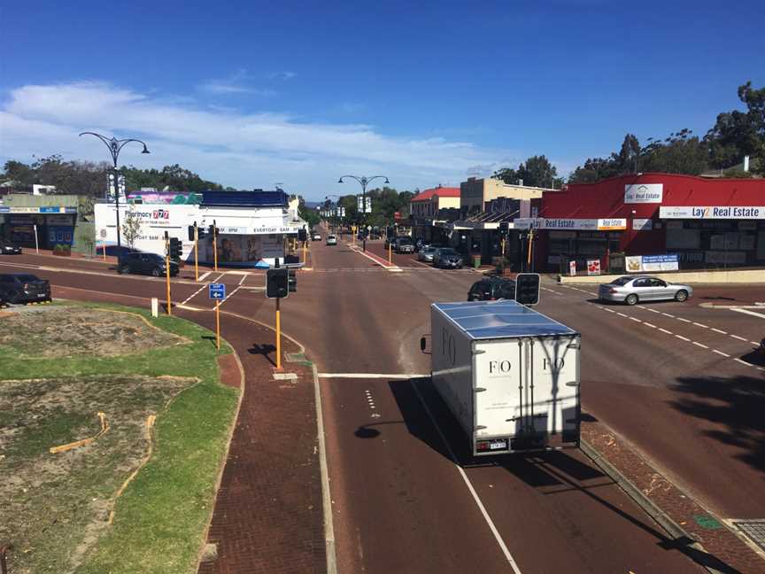 A photographic long shot of commercial buildings lining a road