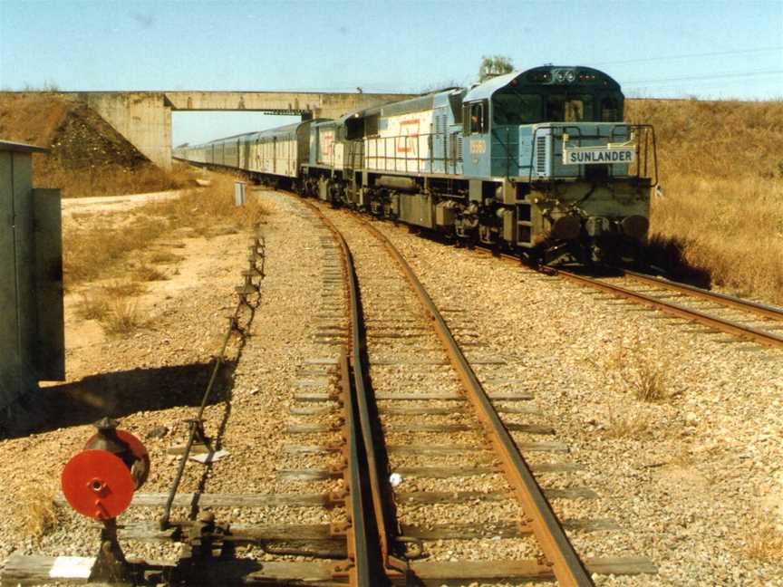 QR loco 1556 and a 1720 class haul the Sunlander northbound through Yabulu, ~1991.jpg