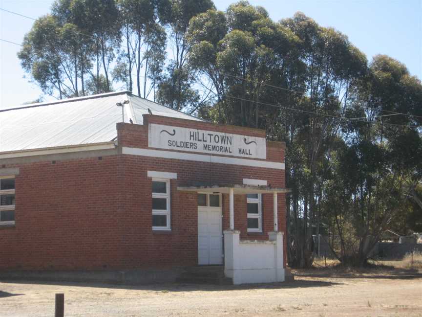 a red brick building with gum trees behind